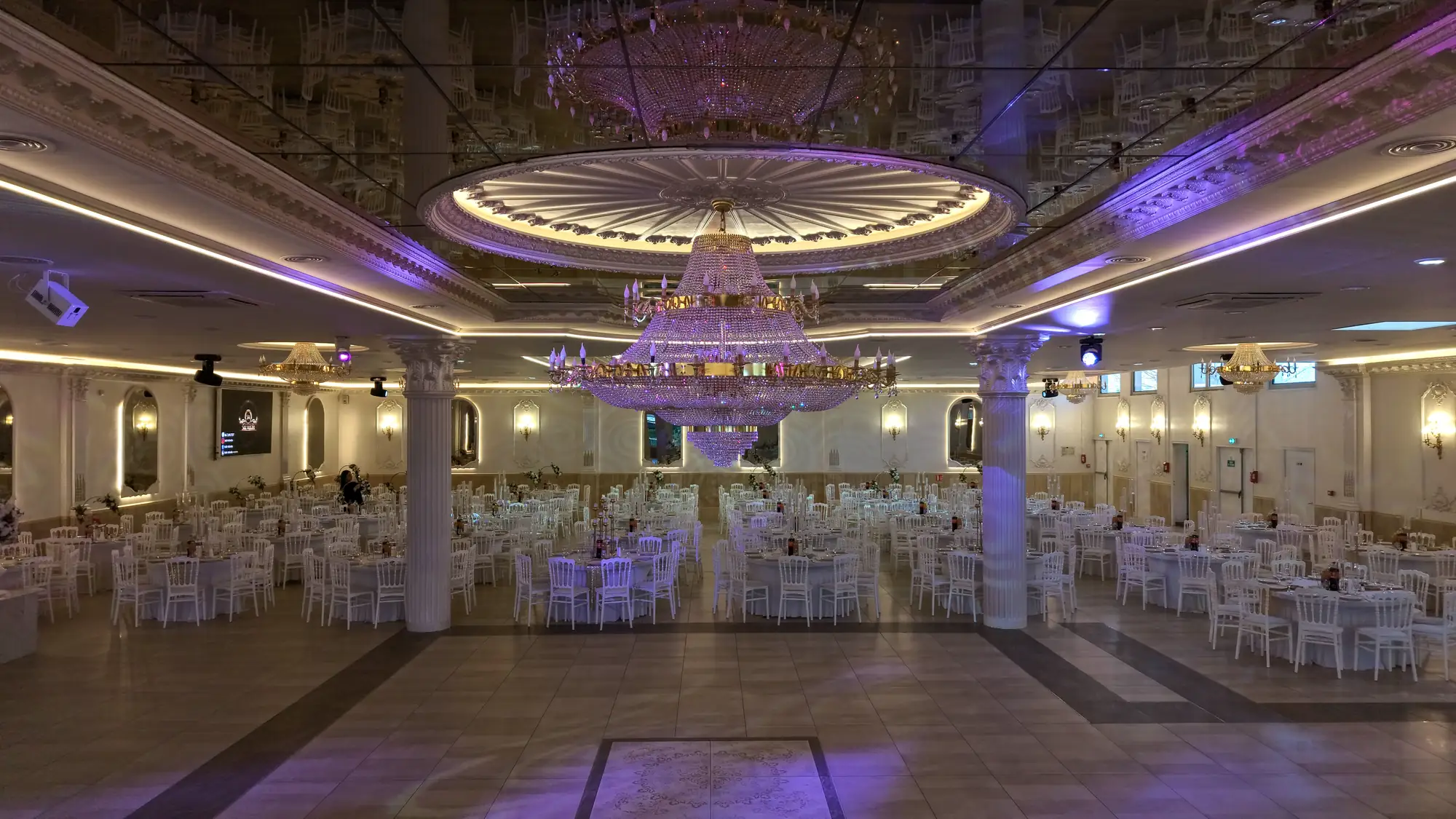 La grande salle sous son plafond à miroirs, dressée pour un mariage